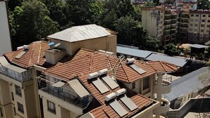 Un edificio residencial de varios pisos con balcones y paneles solares.
