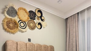 Una habitación de hotel con una cama grande, un cabecero y un adorno en la pared.