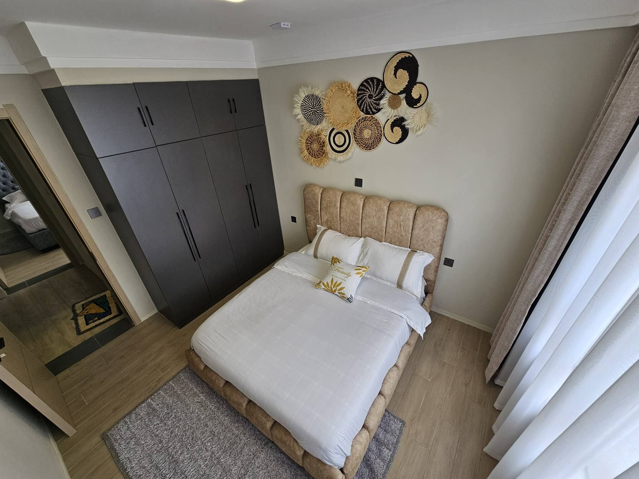 A bedroom with a bed, a wardrobe, and decorative wall art.