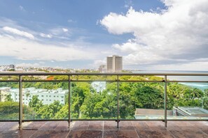 A balcony with a view of a cityscape, including buildings and a body of water. - Apartamento de Lujo Frente al Mar con Jacuzzi (Santo Domingo)