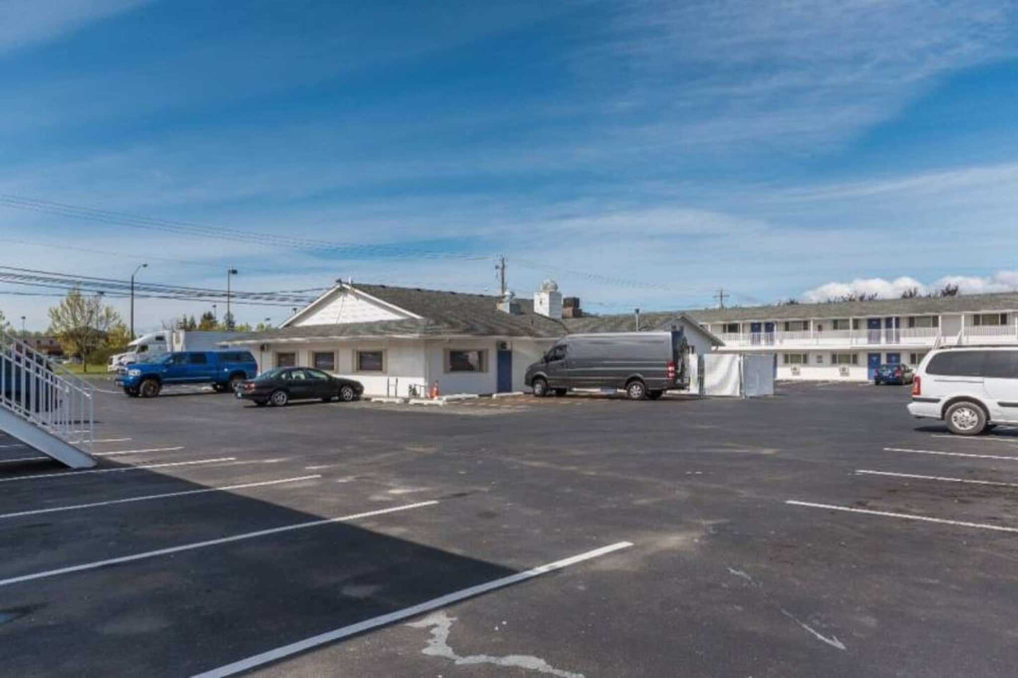 Ein Parkplatz mit einem Motel und einem Gebäude mit geneigtem Dach.