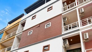 A multi-story building with a ground-level cafe featuring outdoor seating.