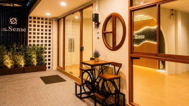A hotel entrance with a reception desk, a glass door entrance, and a sign reading 'The Sense'.