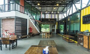 An open-plan interior with a staircase, seating areas, and a kitchen area. - Kong Resort (Vang Vieng)