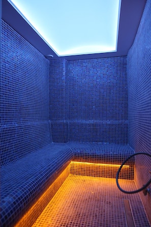 Una sauna moderna con techo inclinado y paredes de azulejos.