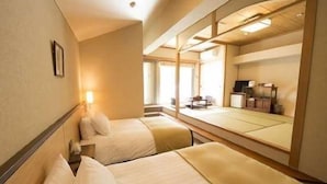 Habitación de hotel con dos camas, un espejo grande y vista al interior de la habitación.