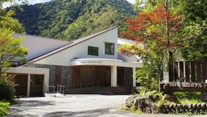 Un edificio moderno con techo plano, entrada cubierta y un letrero que indica que es un hotel.