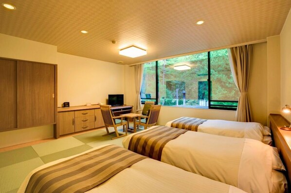 A hotel room with two beds, a desk, a television, and large windows with curtains. - Nikko Tousyougu Kouyouen (Nikko)
