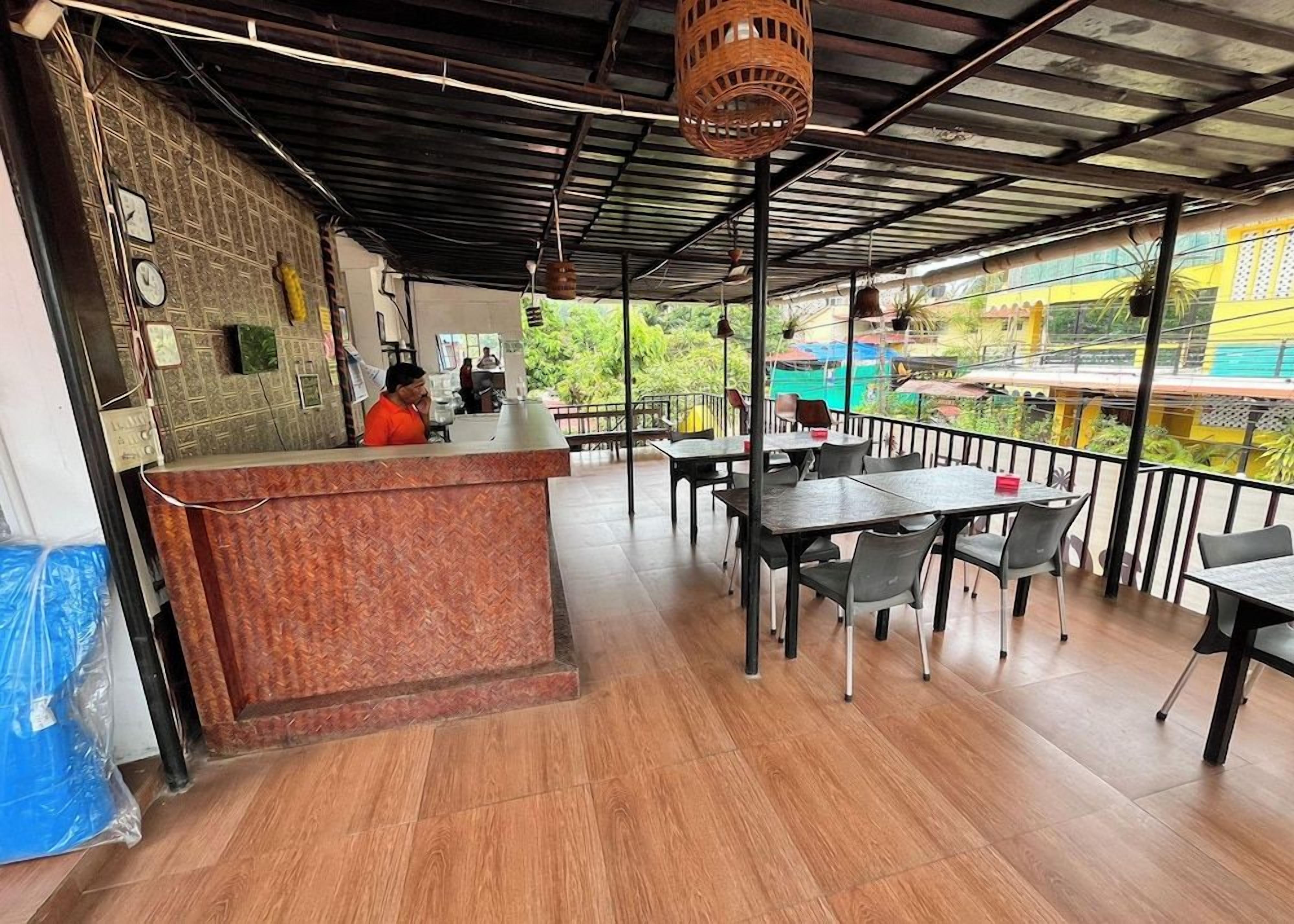 An outdoor cafe with a counter, tables, and chairs.