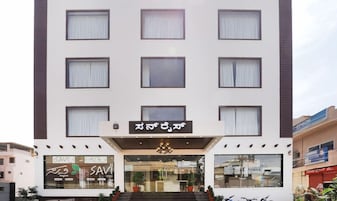 Un hotel de varios pisos con fachada moderna, amplias ventanas y una entrada destacada con un letrero.