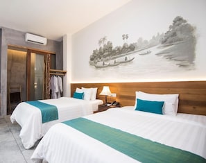 A hotel room with two beds, a wooden headboard, a wall-mounted air conditioner, a rack with clothes, and a painting of a river scene. - Sarina Hotel & Villa (Phnom Penh)