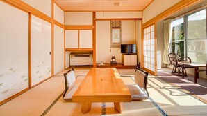 A traditional Japanese-style room with tatami flooring, a low table, and sliding doors. - Yanaginoyu Hotel (Aomori)