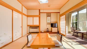 A traditional Japanese-style room with tatami flooring, a low table, and sliding doors.