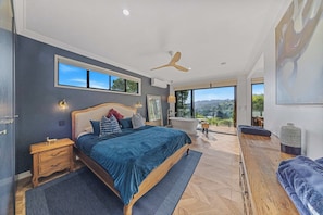 A bedroom with a large bed, a ceiling fan, a view of the outdoors, and a bathtub. - Fletchers Ridge Entire Estate (Montville)