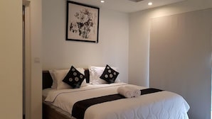 Habitació d'hotel amb un llit, almoines, una obra d'art emmarcada a la paret i una finestra amb persianes.