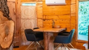 A wooden interior with a dining table, chairs, and an air conditioning unit.