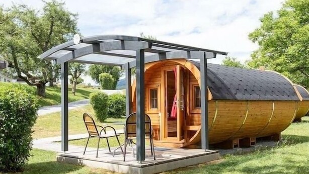 A wooden boat-shaped structure with a covered patio and seating area.