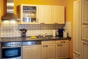 Een keuken met een roestvrijstalen oven, een vaatwasser en een spoelbak.