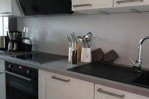 Eine moderne Küche mit Einbauherd, einer Kaffeemaschine und einem Messerblock.