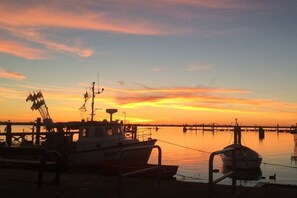 Ein Steg mit Booten bei Sonnenuntergang.
