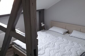 Ein Schlafzimmer mit einem Etagenbett, einer Nachttischlampe und einem Heizkörper.