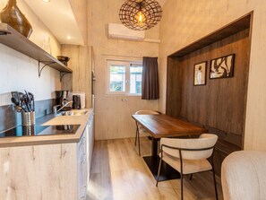 Eine moderne Küche mit einer Holz Arbeitsplatte, Edelstahlgeräten und einer Pendelleuchte.