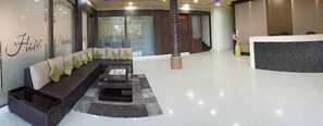 A hotel reception area with a reception desk, a seating area with a sofa and chairs, and a reception counter. - Treebo Hotel Pemaling (Guwahati)