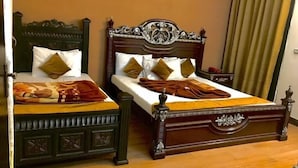 Een tweepersoonsbed met een houten hoofdbord en voeteneinde, twee kussens en een deken.