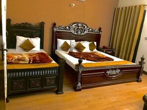 Ein Doppelbett mit hölzernem Kopfteil und Fußteil, zwei Kissen und eine Decke.