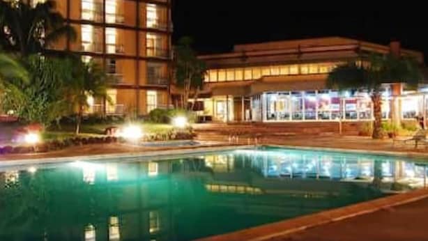 Un hotel amb piscina, zones d'estar a l'exterior i una façana ben il·luminada.