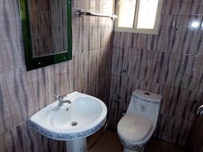 Un bany amb un lavabo blanc, un vàter i un mirall.