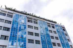 Edifici d'hotel de diversos pisos amb façana moderna, grans finestres i un rètol que diu 'HOTEL SUNSHINE'.