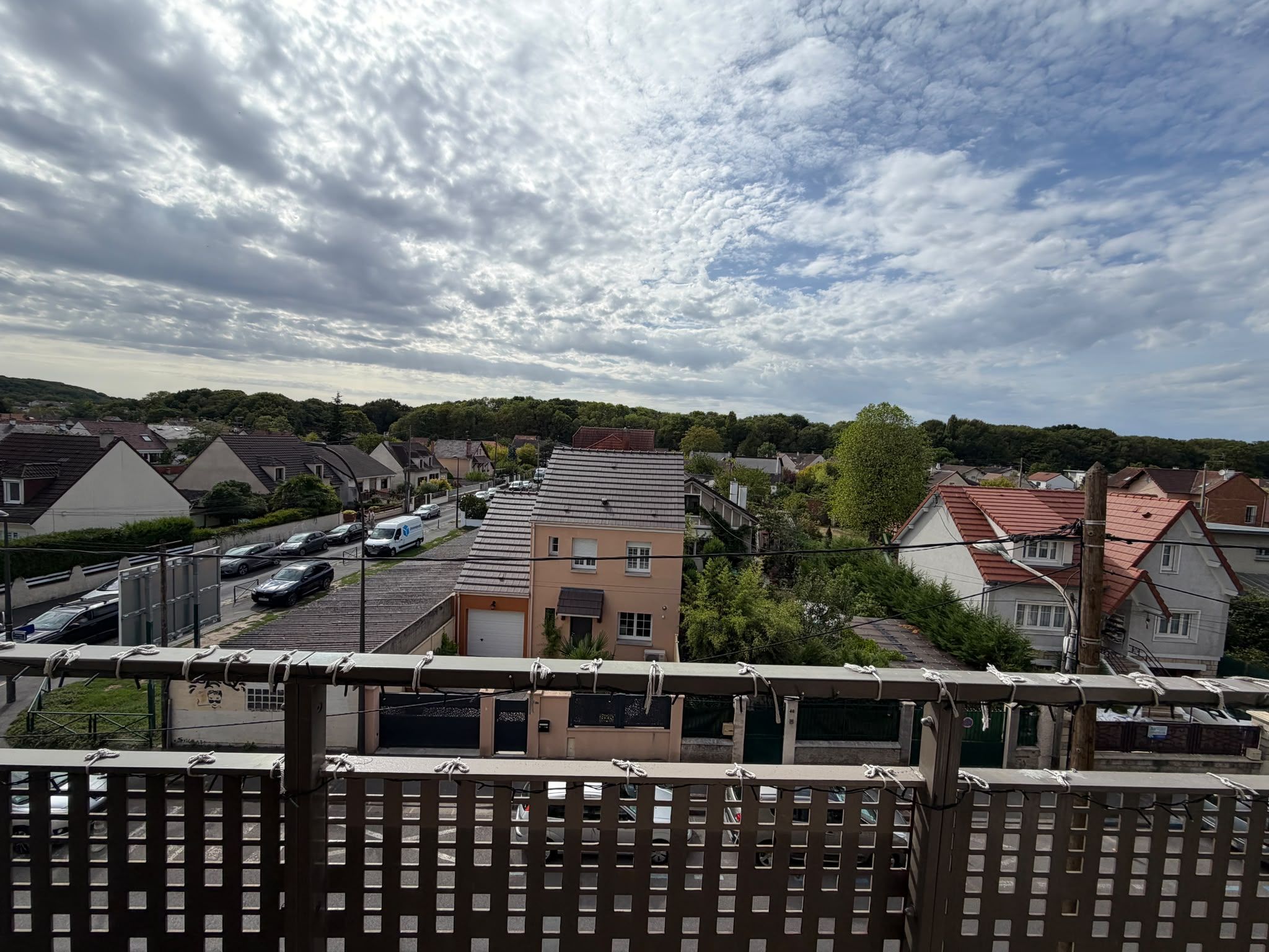 Un quartier résidentiel avec des maisons, un parking et un ciel nuageux.