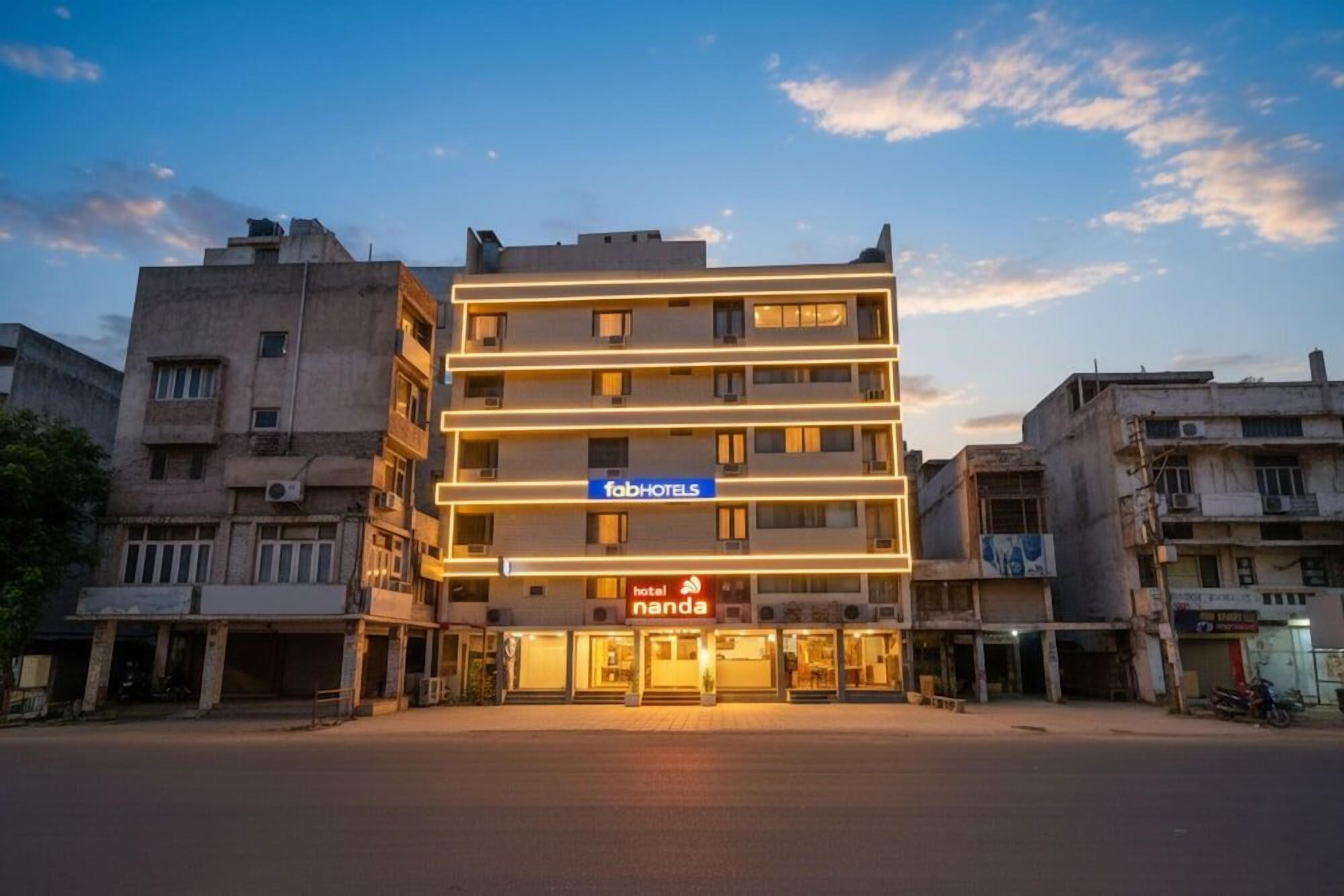 A multi-story hotel with a flat facade, a prominent 'fabHOTELS' sign, and a 'hotel nanda' sign below.