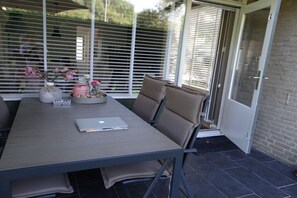 An outdoor patio with a table, chairs, and a laptop. - Holiday apartment with 2 bedrooms (Dishoek)