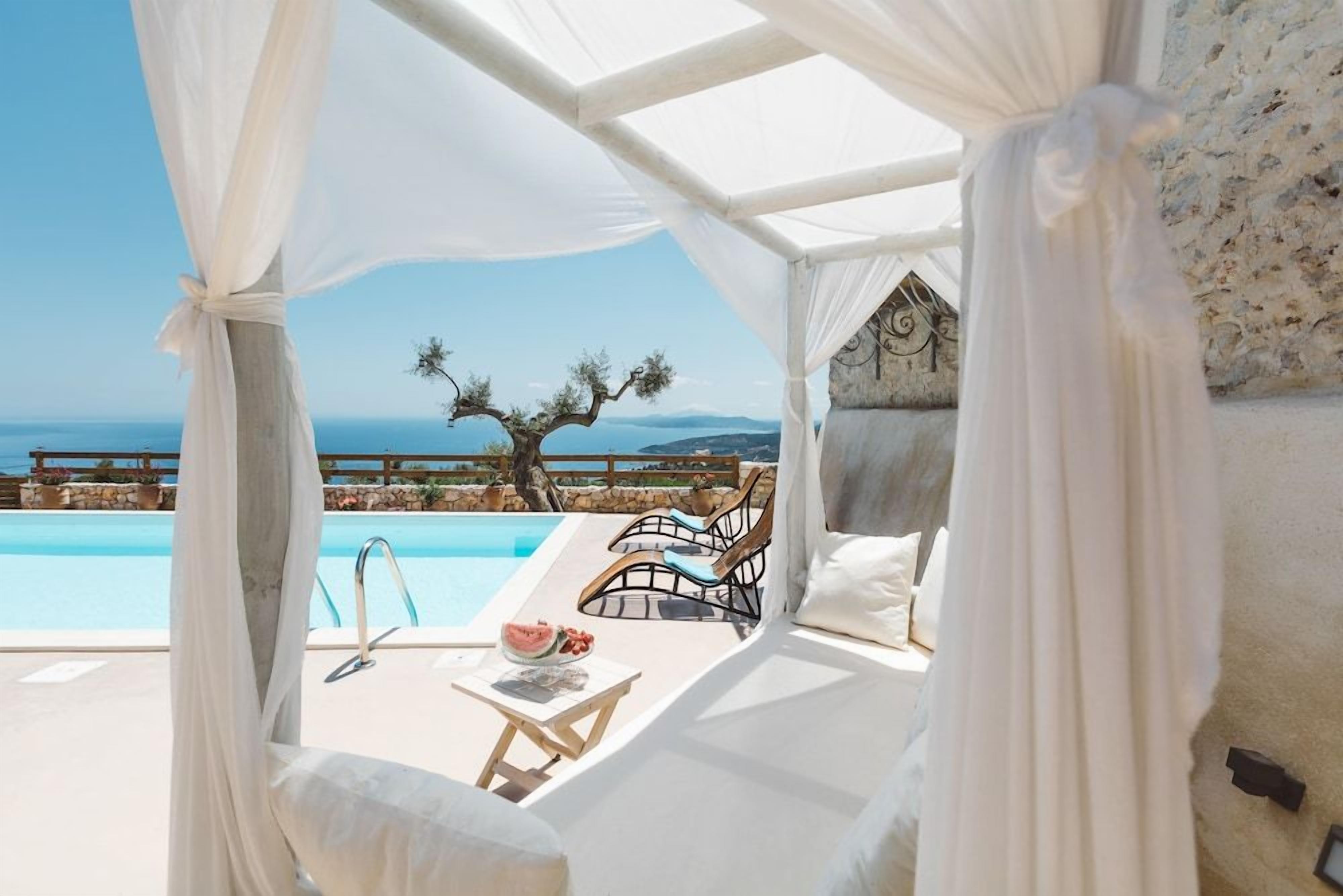 A private pool area with a canopy, lounge chairs, and a view of the sea.
