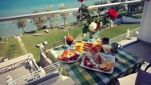 Un balcón con mesa listo para el desayuno, con vistas al mar.