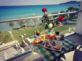 Un balcón con mesa listo para el desayuno, con vistas al mar.