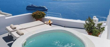 A hot tub with a view of the sea and a small island.