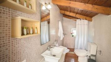 A bathroom with a tiled backsplash, a wooden ceiling, a sink, a toilet, and a shower curtain.