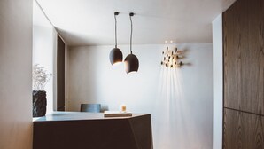 En moderne receptionsdisk med en mørk bordplade, en stol og en bog med titlen "The Design Hotels' Book".