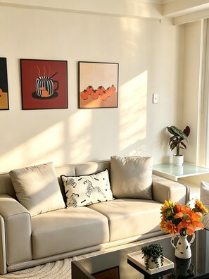 A modern living room with a beige sofa, a coffee table, and wall art. - Spacious 3 bedrooms Apartment in Sydney CBD /2 Full bathrooms (Sydney)
