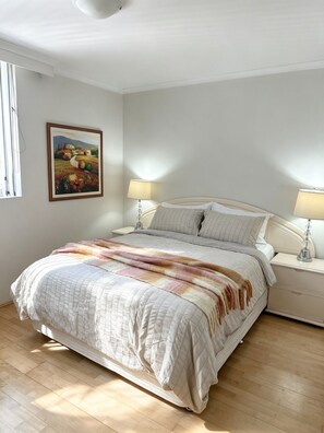 A bedroom with a bed, two bedside lamps, a painting on the wall, and a window with curtains. - Spacious 3 bedrooms Apartment in Sydney CBD /2 Full bathrooms (Sydney)