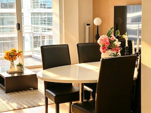A modern dining area with a round table, black chairs, and a vase of flowers. - Spacious 3 bedrooms Apartment in Sydney CBD /2 Full bathrooms (Sydney)