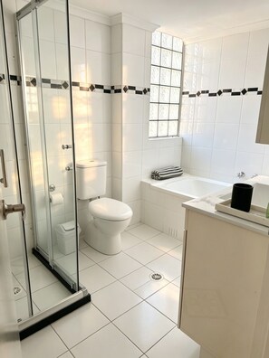 A modern bathroom with a glass shower enclosure, a toilet, a bathtub, and a sink. - Spacious 3 bedrooms Apartment in Sydney CBD /2 Full bathrooms (Sydney)