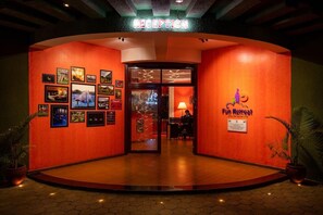 Un área de recepción con pared roja, cuadros enmarcados y un letrero para un retiro divertido.