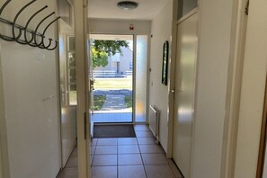 Un couloir avec une porte donnant sur un espace extérieur abrité.
