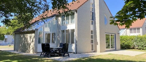 Ein modernes Gebäude mit Glasfassade, Backsteinfassade und geneigtem Dach.