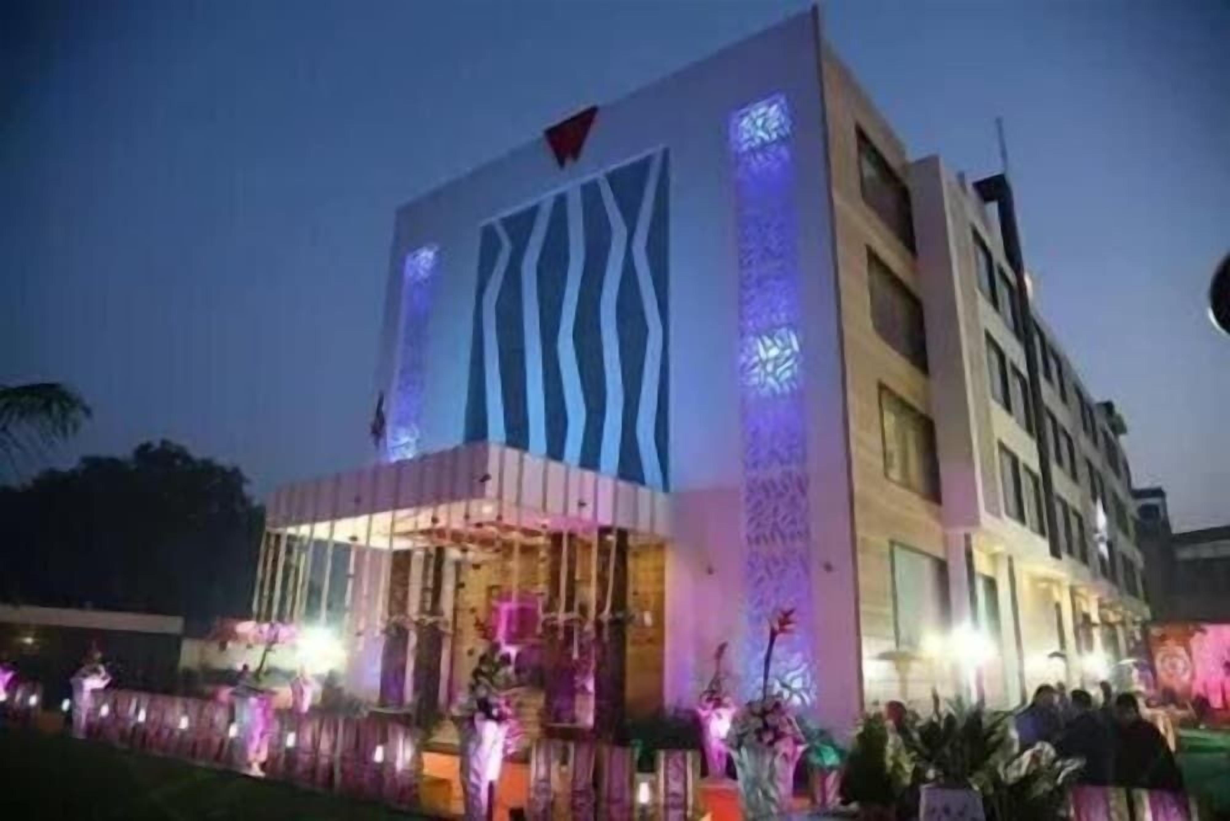 A modern building with a prominent vertical design element and a flag at the top.