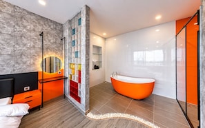 Ein modernes Badezimmer mit freistehender Badewanne, einer Duschkabine und einem Waschtisch mit Spiegel.